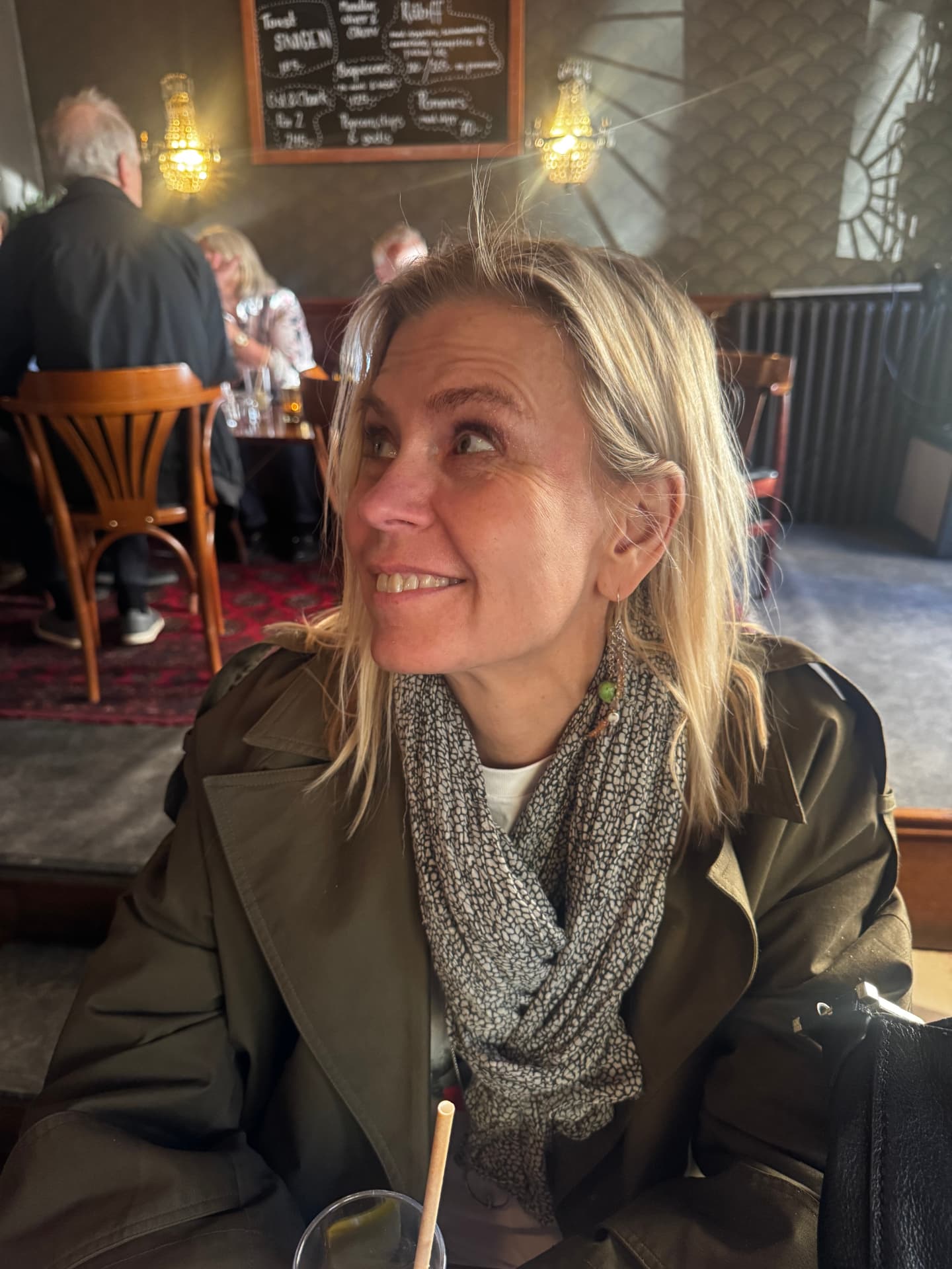 Portrait of author Cecilia Tibell wearing a green jacket and scarf